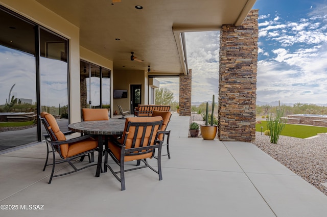 view of patio featuring outdoor dining area and a ceiling fan