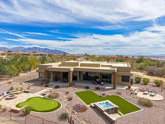 rear view of house with a patio area, a mountain view, and an outdoor fire pit