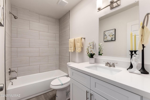 bathroom featuring visible vents, toilet, tub / shower combination, vanity, and wood finished floors