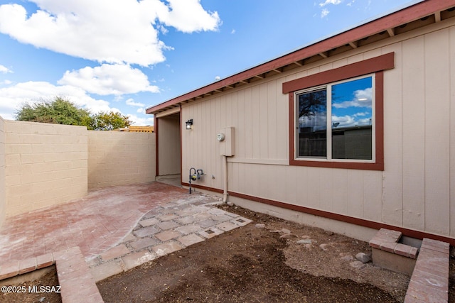 view of side of property featuring fence and a patio