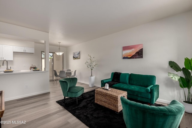 living area featuring light wood-type flooring and baseboards