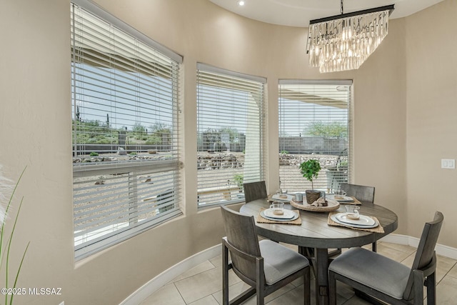 dining space with an inviting chandelier, baseboards, and light tile patterned flooring