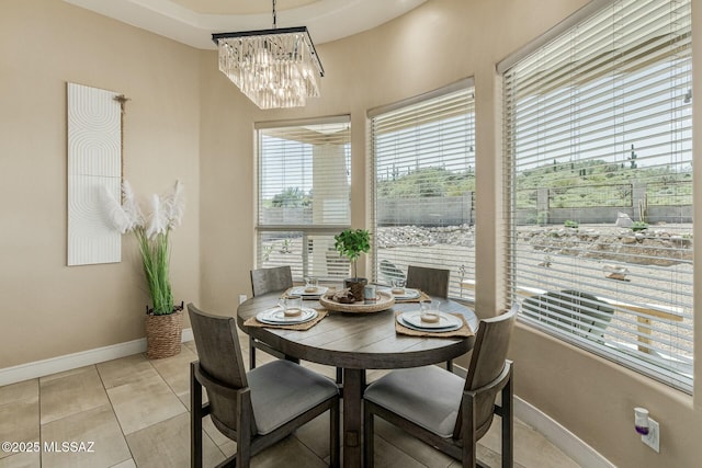 dining room featuring an inviting chandelier, baseboards, and light tile patterned floors