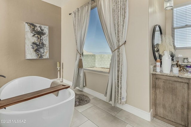 full bath featuring tile patterned flooring, baseboards, and a freestanding bath