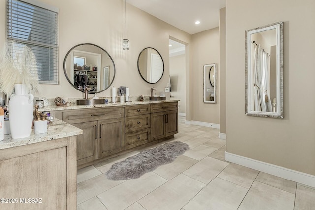 full bath with tile patterned flooring, vanity, and baseboards