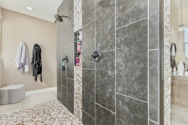 full bath featuring baseboards, a tile shower, and recessed lighting