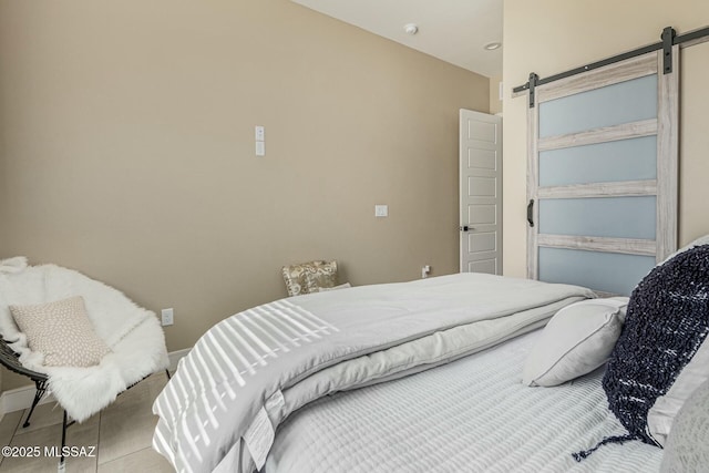 bedroom featuring a barn door and tile patterned floors