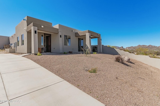 pueblo-style home featuring a mountain view and stucco siding