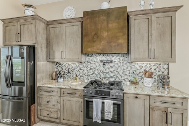 kitchen featuring appliances with stainless steel finishes, light brown cabinets, light stone counters, and tasteful backsplash