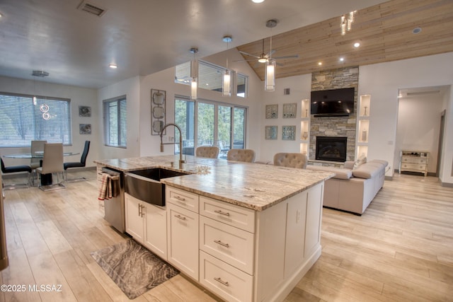 kitchen with dishwasher, light wood-style flooring, a sink, and visible vents