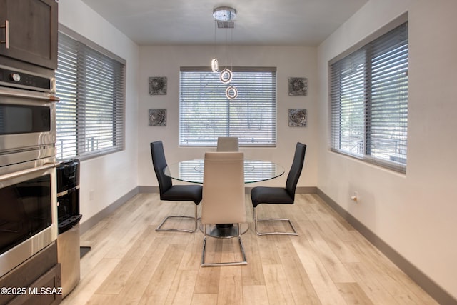 dining room featuring baseboards and light wood-style floors