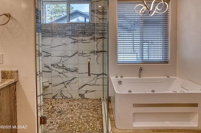 full bathroom featuring a whirlpool tub, an inviting chandelier, and a marble finish shower