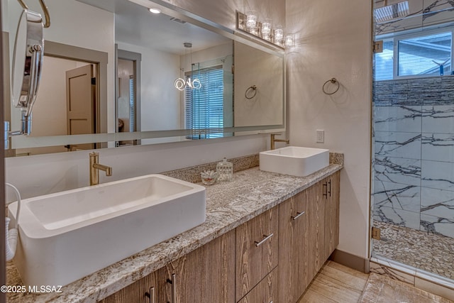 bathroom with double vanity, a stall shower, and a sink