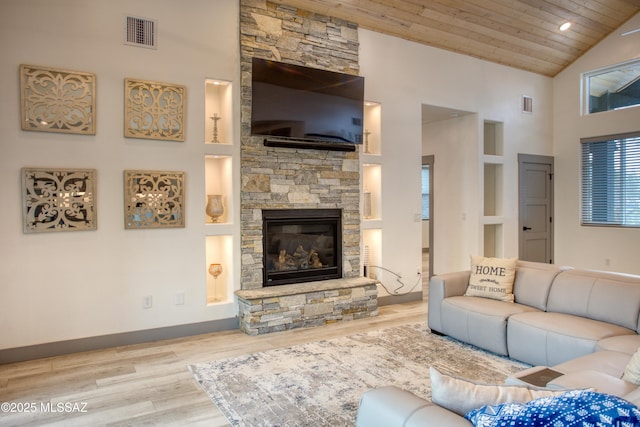 living room with wood ceiling, a fireplace, visible vents, and wood finished floors