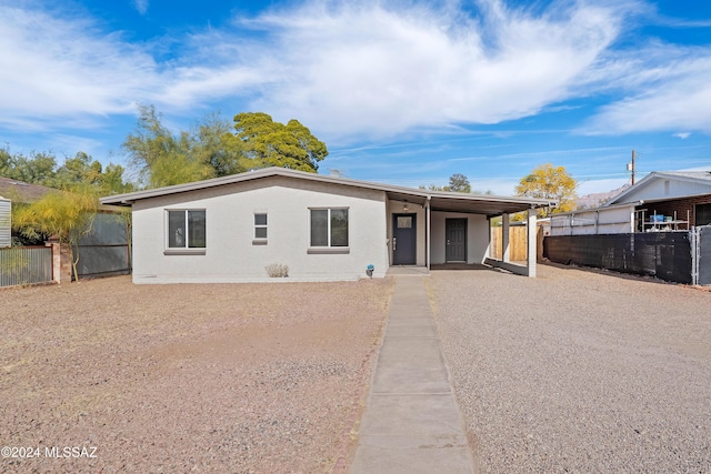 view of front facade featuring a carport, brick siding, and fence