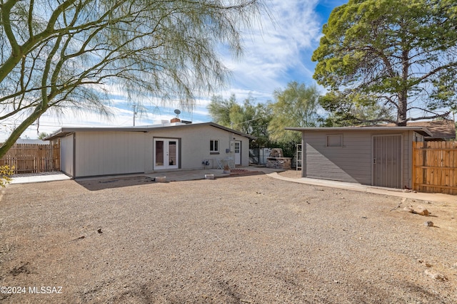 back of house with an outbuilding, french doors, a patio area, and fence