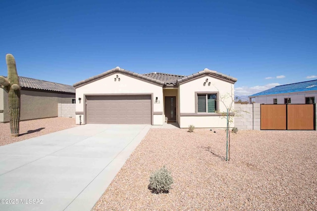 mediterranean / spanish home with a garage, concrete driveway, a tiled roof, fence, and stucco siding