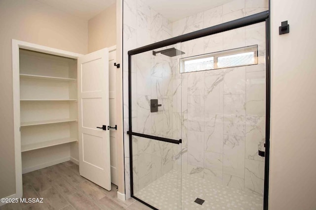bathroom with a shower stall and wood finished floors