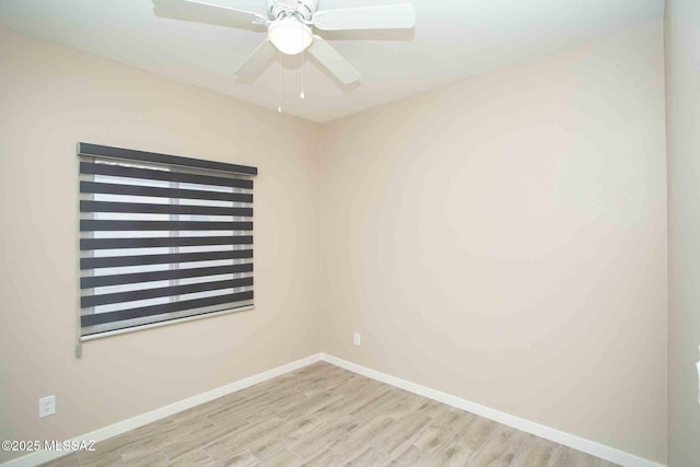 empty room with baseboards, wood finished floors, and a ceiling fan