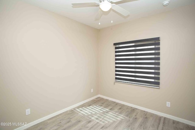 empty room with wood finished floors, ceiling fan, and baseboards
