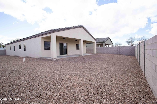 back of property with a patio, a ceiling fan, stucco siding, and a fenced backyard