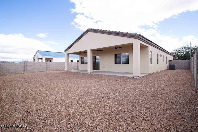 back of property with a patio, stucco siding, a ceiling fan, central AC, and a fenced backyard