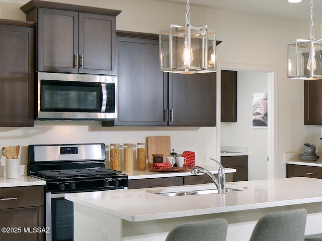 kitchen featuring dark brown cabinetry, appliances with stainless steel finishes, light countertops, and a sink