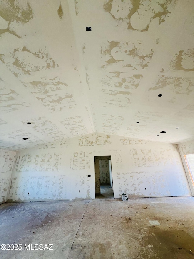 unfurnished room with lofted ceiling