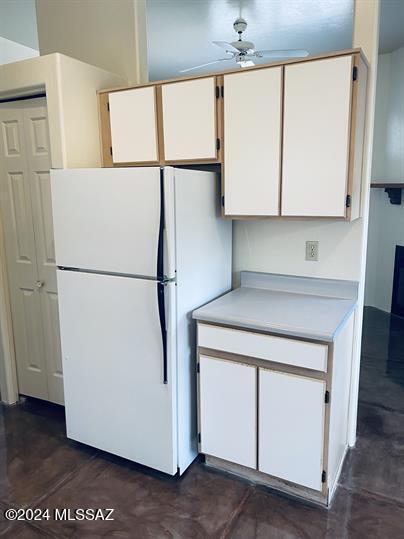 kitchen featuring white cabinets, light countertops, and freestanding refrigerator