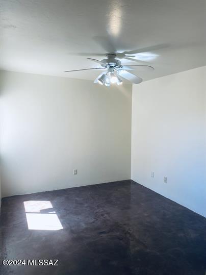 spare room featuring ceiling fan and concrete flooring