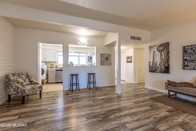 interior space with visible vents, washer / dryer, baseboards, and dark wood-style flooring