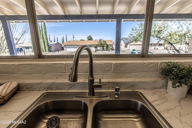 interior details with light stone countertops and a sink