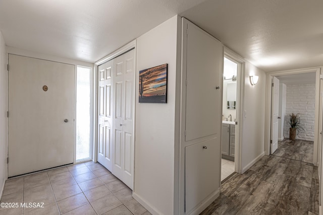 foyer entrance with light tile patterned floors and baseboards