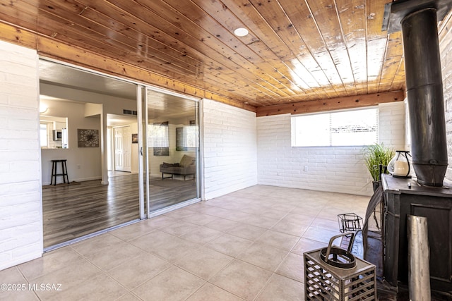 sunroom featuring wooden ceiling and a wood stove