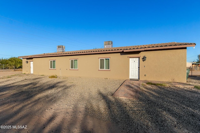 rear view of house featuring stucco siding