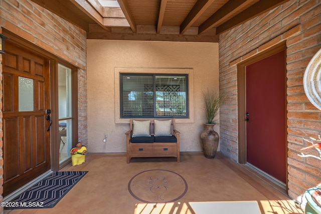 entrance to property featuring stucco siding and brick siding