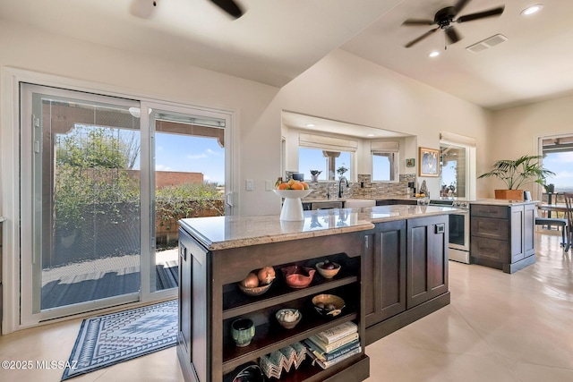 kitchen featuring decorative backsplash, open shelves, visible vents, and a center island