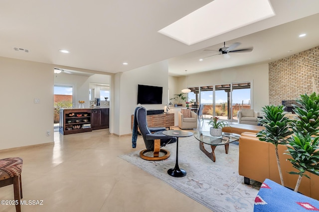 living area featuring a ceiling fan, visible vents, a skylight, recessed lighting, and finished concrete floors