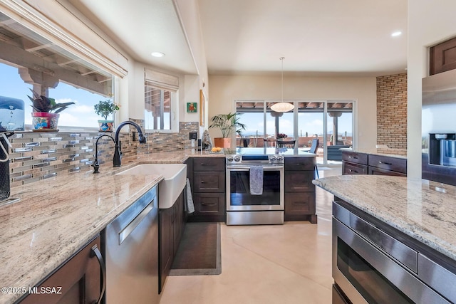 kitchen with a sink, decorative backsplash, appliances with stainless steel finishes, and a wealth of natural light