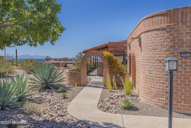 view of gate with a mountain view and fence