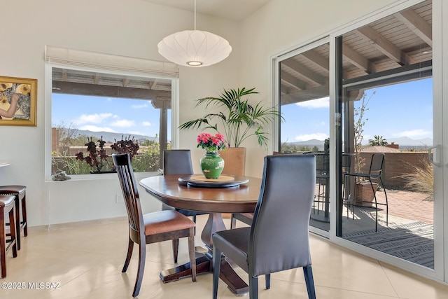 tiled dining area with a mountain view and baseboards