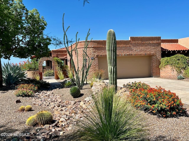 view of front of home featuring concrete driveway, an attached garage, and brick siding