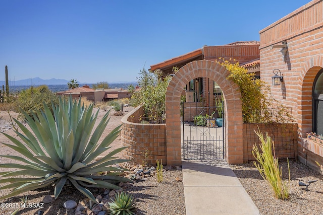 view of gate with a mountain view and fence