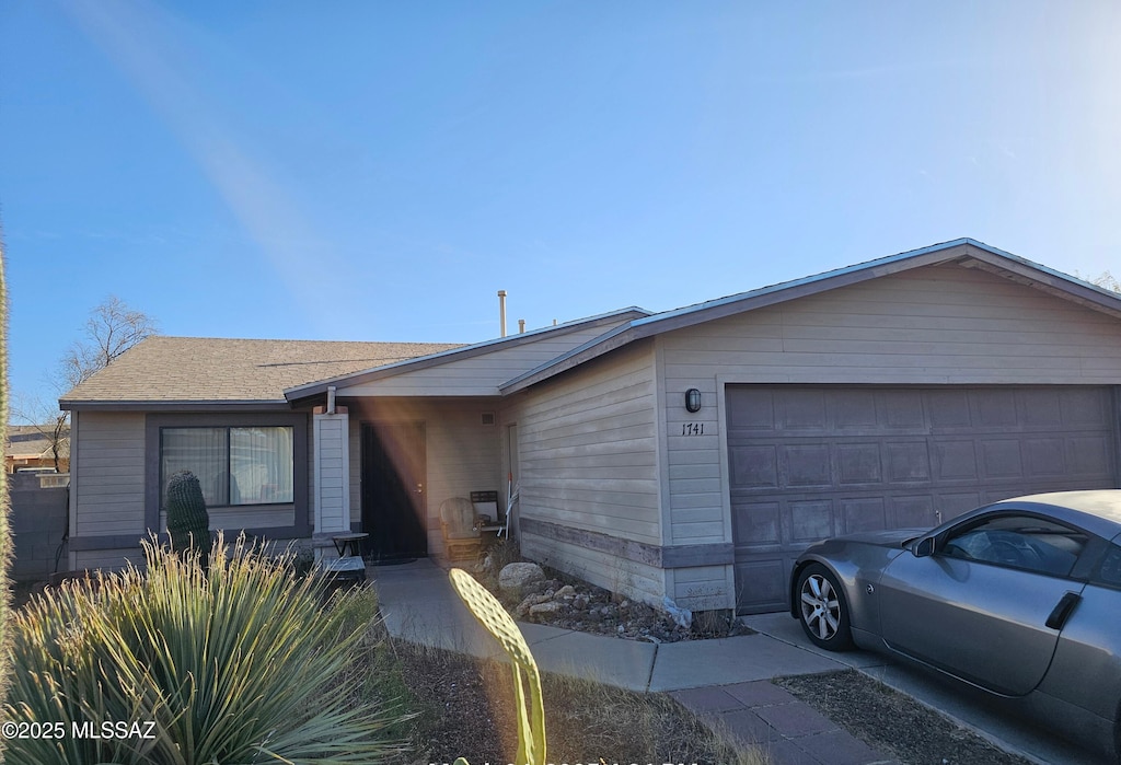 view of front of property with a shingled roof and an attached garage