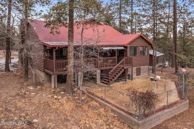 back of property with stairs, log siding, metal roof, and a wooden deck