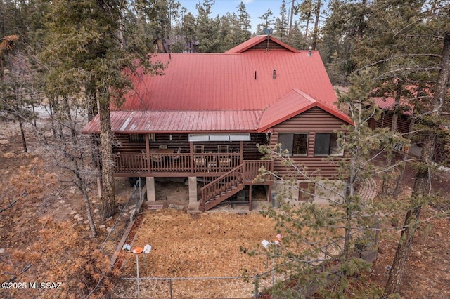 exterior space featuring stairs, metal roof, and log exterior