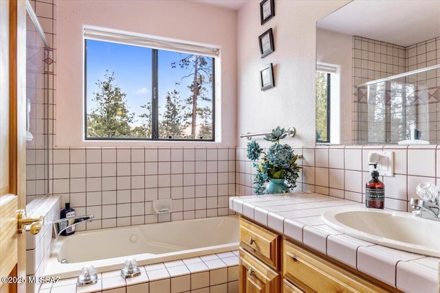 bathroom with a garden tub, a shower stall, a wealth of natural light, and vanity