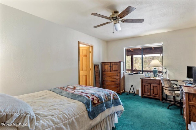 bedroom with ceiling fan, a textured wall, a textured ceiling, and dark carpet