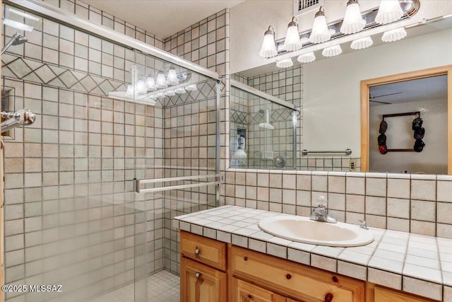 full bathroom featuring a stall shower, backsplash, and vanity