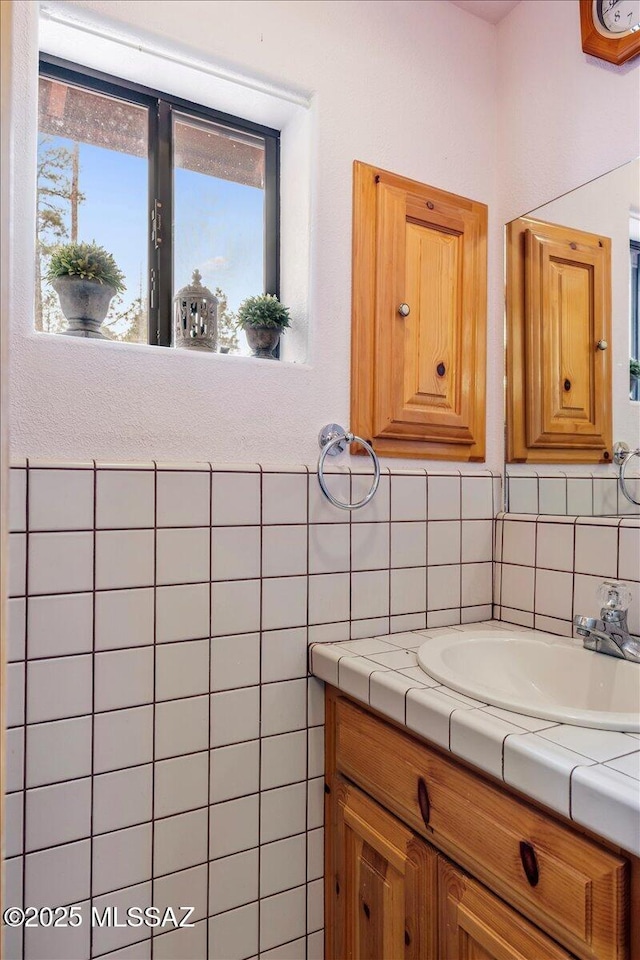 bathroom featuring vanity and tile walls